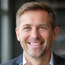 Retrato de un hombre de mediana edad sonriendo con confianza.